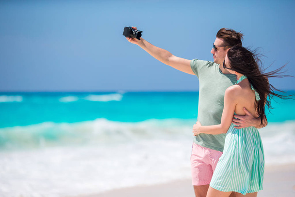 Szczęśliwa para robienie zdjęć na plaży na wakacje - Zdjęcie, obraz