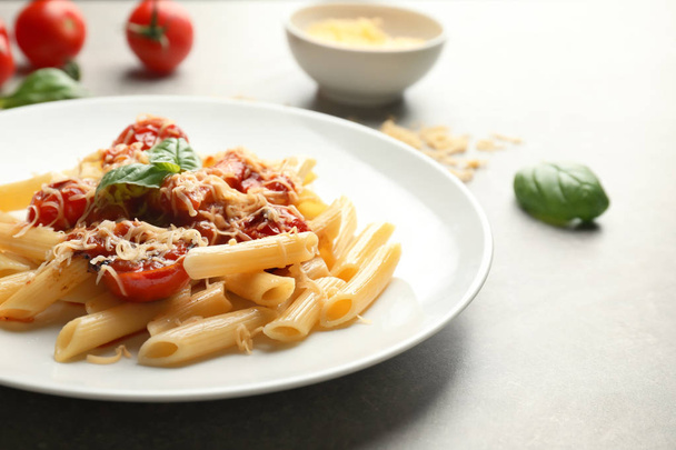 Plate with tasty penne pasta on grey table - Zdjęcie, obraz