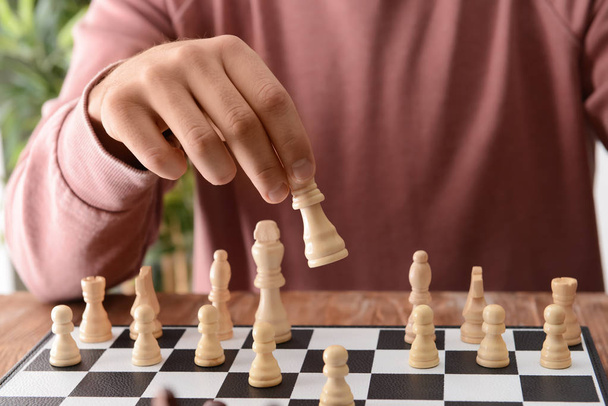 Hombre jugando ajedrez en mesa de madera - Foto, Imagen