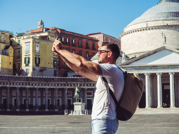 Handsome man with a phone on the background of the square - Foto, imagen
