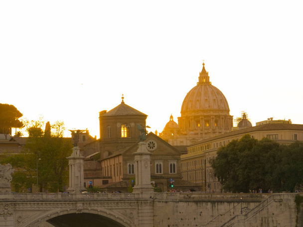 Raios de sol dourados iluminam a histórica Capela Sistina na Cidade do Vaticano. Basílica de São Pedro de tirar o fôlego em uma pitoresca manhã de verão. Inúmeros viajantes em viagem turística da Roma antiga
. - Foto, Imagem