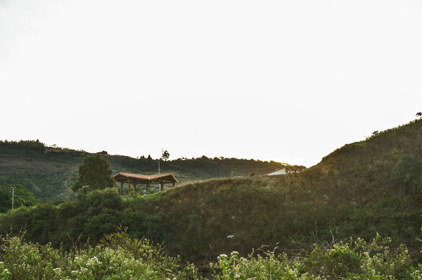 paisaje de una colina con una casa en el atardecer - Fotografie, Obrázek