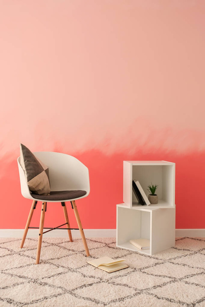 Poltrona confortável perto da parede rosa
 - Foto, Imagem