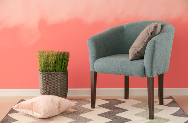 Mukava nojatuoli lähellä vaaleanpunainen seinä
 - Valokuva, kuva