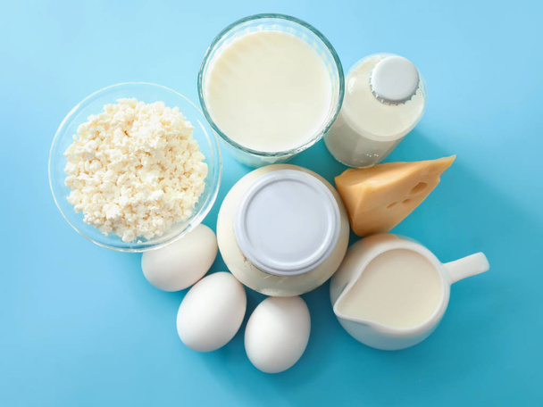 Вкусные молочные продукты с яйцами на цветном столе
 - Фото, изображение