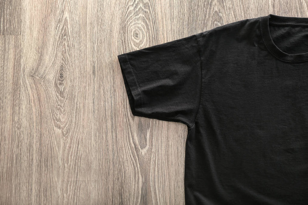 Blank black t-shirt on wooden background - Foto, Imagen