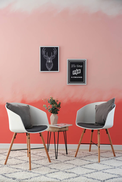 Mukava nojatuolit lähellä vaaleanpunainen seinä
 - Valokuva, kuva