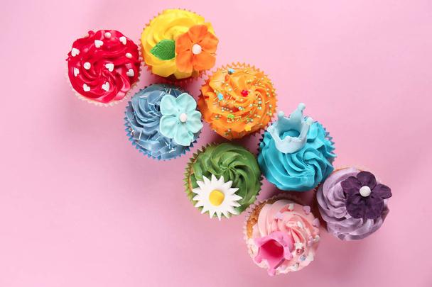 Delicious cupcakes on color background - 写真・画像