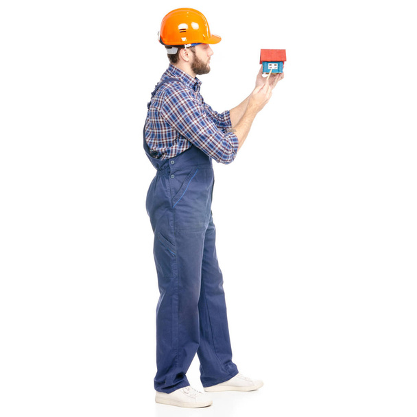 Молодий чоловік будівельник промисловості працівник хардхаус з будинком в руці
 - Фото, зображення
