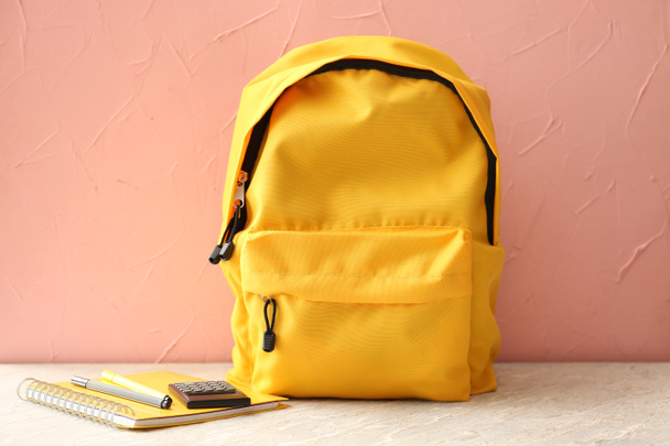 Sac à dos avec fournitures scolaires sur table lumineuse
 - Photo, image