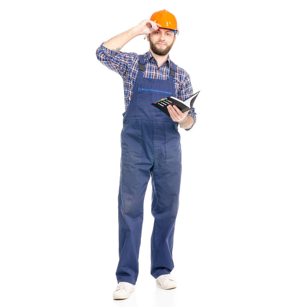 Young man builder industry worker hardhat  with a notebook and pen in hand - Foto, Imagen