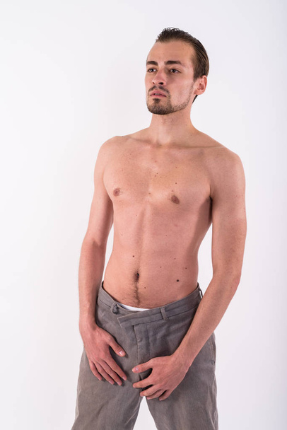 Studio shot of young bearded man standing and thinking while loo - Foto, immagini