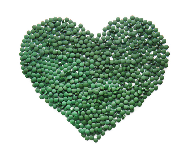 Heart made of spirulina tablets on white background - Photo, Image