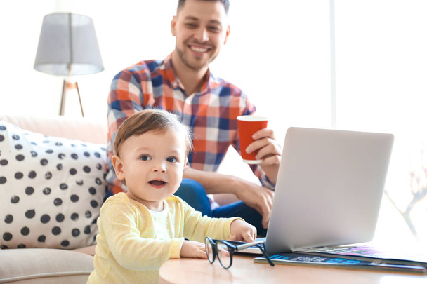 Handsome dad with his son using laptop at home - Photo, Image