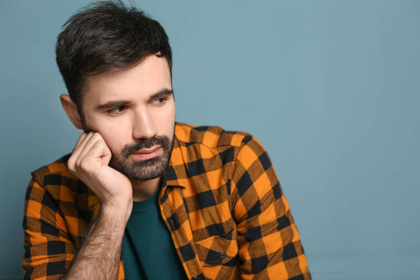 Young bearded man in casual clothes on color background - Photo, Image