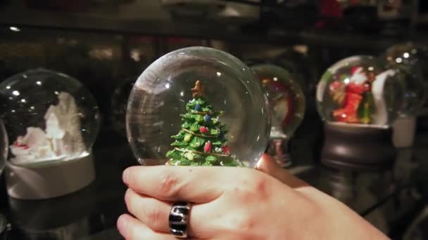 Gyönyörű téli hógömb belsejében a karácsonyfa. Lassú mozgás. - Felvétel, videó
