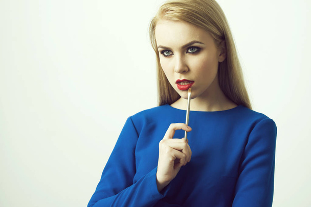 Girl with makeup brush at red lips - 写真・画像