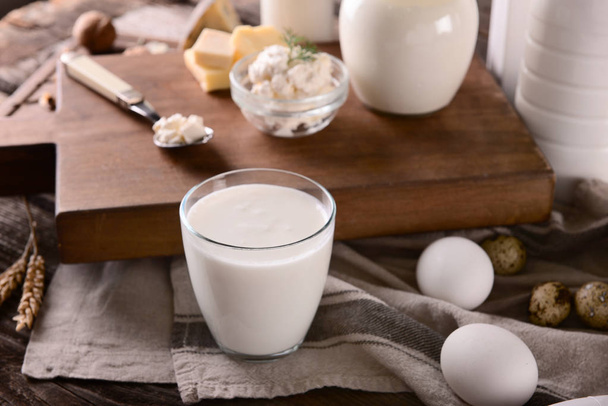 Glass of milk with eggs on wooden table - Foto, imagen