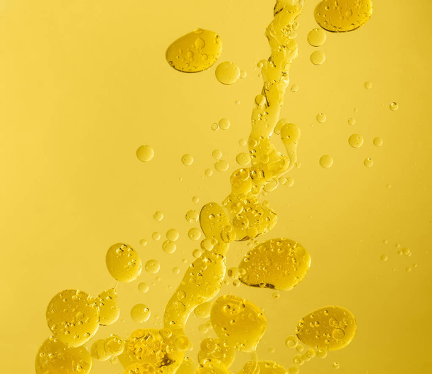 Drops of oil on color background - Фото, изображение