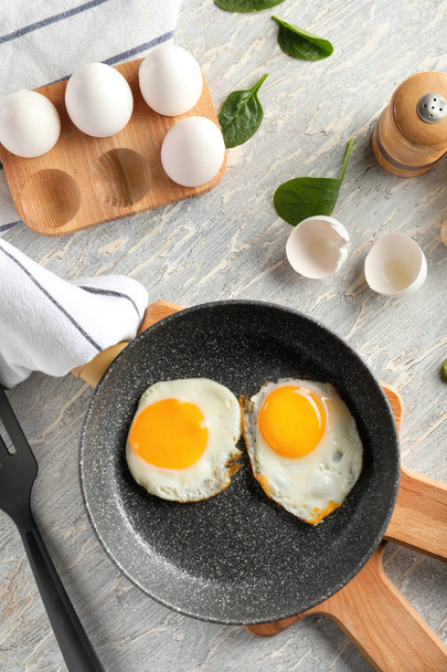Sartén con sabrosos huevos fritos en tablas de madera
 - Foto, Imagen