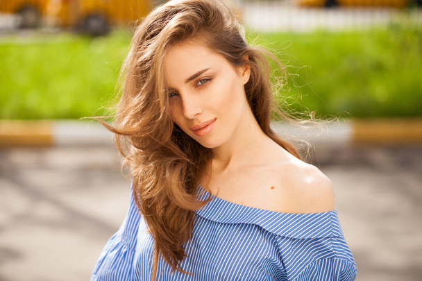 Closeup portrait of a young beautiful brunette woman on summer background - Fotografie, Obrázek