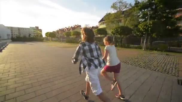 Boy And Girl Run Together Holding Hands On Asphalt. They Have A Lot of Fun. - Materiał filmowy, wideo