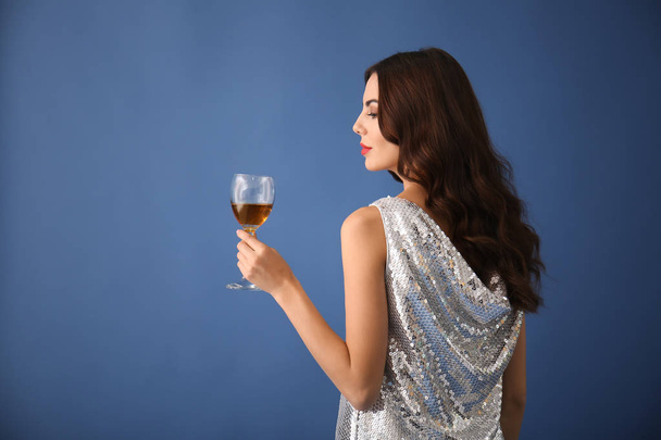 Beautiful young woman with glass of wine on color background - Photo, Image