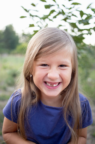Young little girl without a front tooth in the countryside. - Foto, Imagen