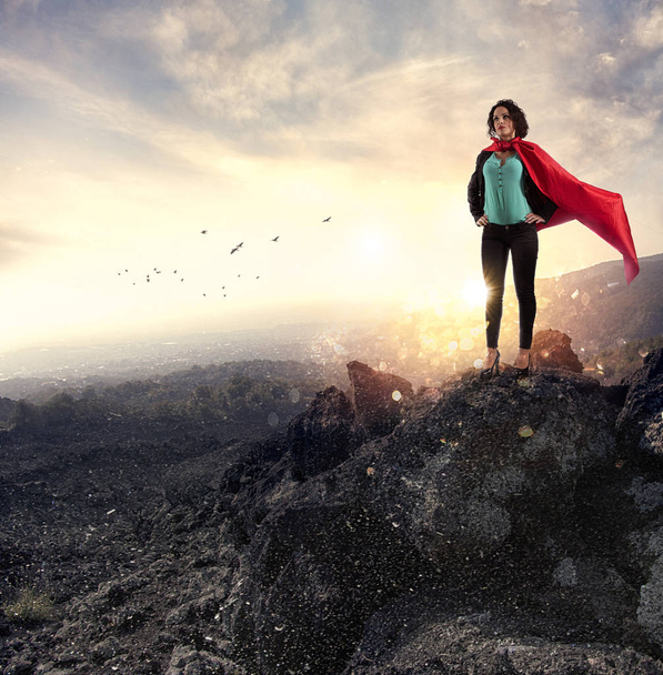 La exitosa mujer de negocios actúa como una superheroína en una montaña. Concepto de determinación y éxito
 - Foto, imagen