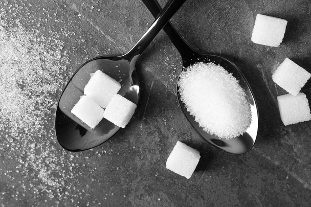 Cucchiai con zucchero sulla tavola grigia
 - Foto, immagini