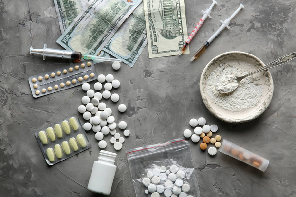 Наркотики з грошима на сірому фоні. Поняття залежності
 - Фото, зображення