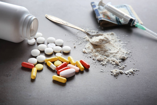 Geneesmiddelen met spuit en geld op grijze achtergrond. Concept van verslaving - Foto, afbeelding