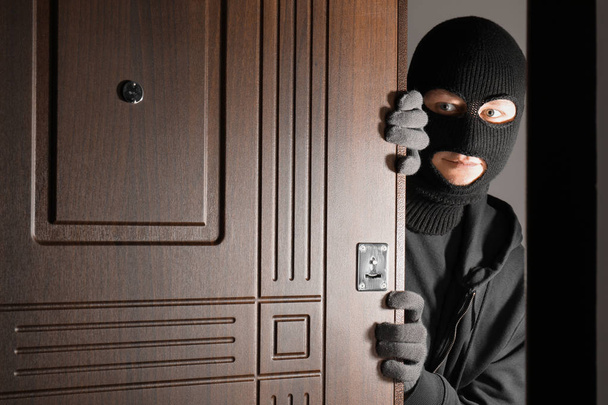 Male thief entering house through door at night - Zdjęcie, obraz