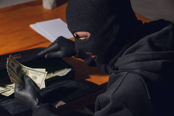 Mężczyzna złodziejaszka kradnącego Aktówka z pieniędzy w biurze - Zdjęcie, obraz