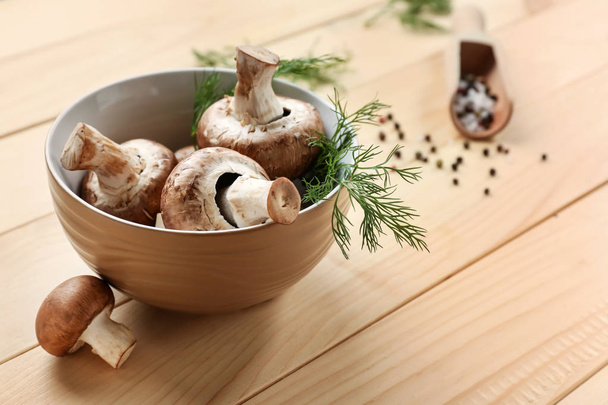 Bowl with fresh mushrooms on wooden table - Photo, Image