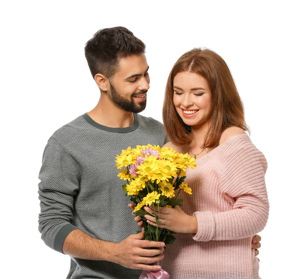 junger Mann, der seiner geliebten Freundin schöne Blumen auf weißem Hintergrund schenkt. Feier zum Valentinstag - Foto, Bild