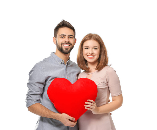 Loving young couple holding fabric heart on white background. Celebration of Saint Valentine's Day - Foto, immagini