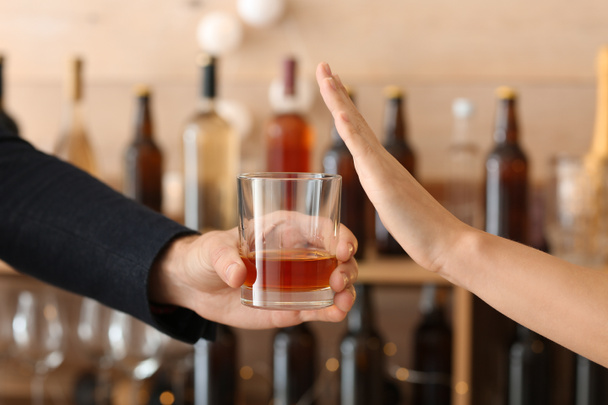 Mann mit Whiskey-Glas und Frau, die sich weigert, in Bar zu trinken - Foto, Bild