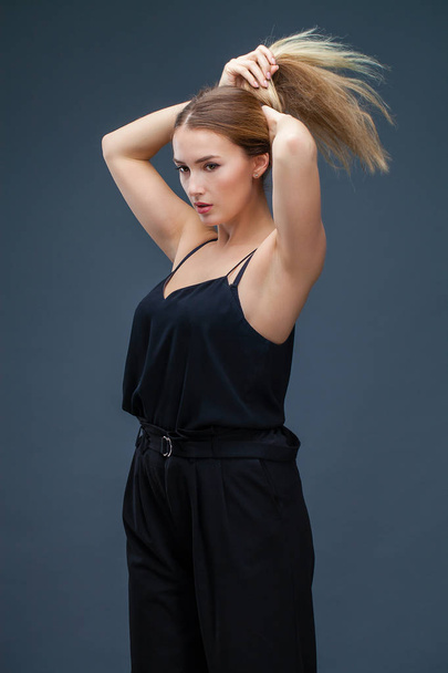 Happy Beautiful blonde woman in black dress, studio isolated on gray background - 写真・画像
