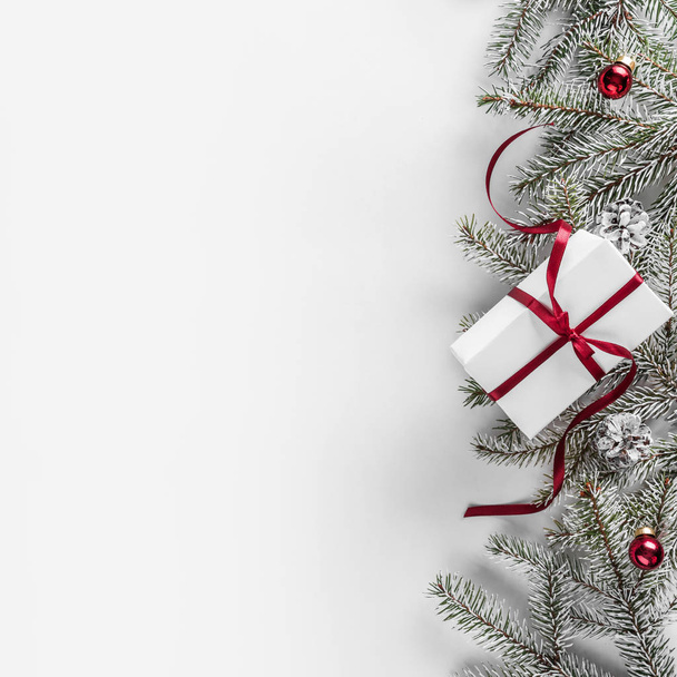 Caixas de presente de Natal em fundo branco com ramos de abeto, cones de pinho, fita vermelha. Tema de Natal e Feliz Ano Novo. Deitado plano, vista superior
 - Foto, Imagem