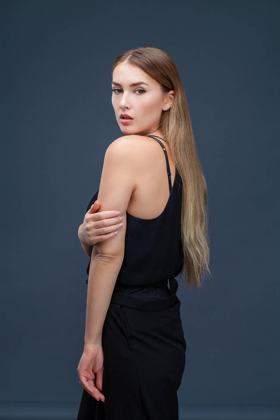 Happy Beautiful blonde woman in black dress, studio isolated on gray background - Foto, afbeelding
