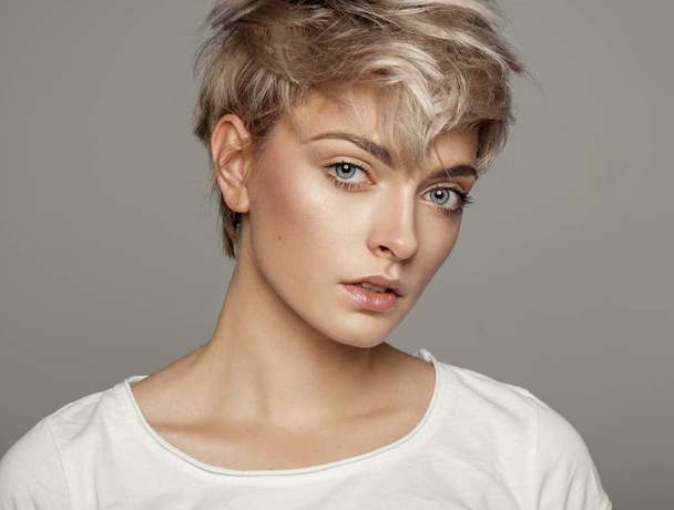 Portrait of fashion trendy haircut girl with copy space isolated on gray background - Valokuva, kuva