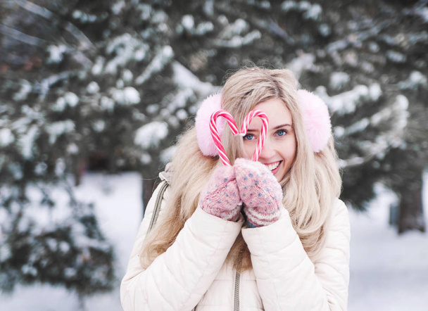 Χαριτωμένο νεαρή κοπέλα με Χριστουγεννιάτικο καραμέλες. Ευτυχισμένος χειμερινές διακοπές.  - Φωτογραφία, εικόνα