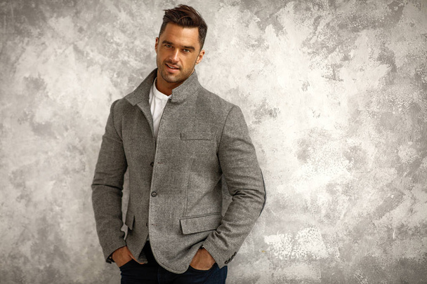 Portrait of handsome smiling man in gray stylish jacket with copy space for your text - Foto, imagen
