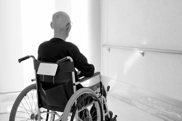 Вид пожилого или пожилого человека на инвалидном кресле в больнице
 - Фото, изображение