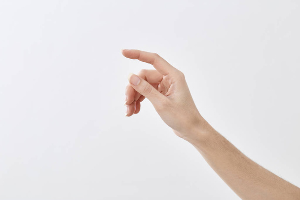 Крупним планом жіноча рука вказує ізольовано на білому тлі. Існує порожній простір для дизайну природного світла
. - Фото, зображення