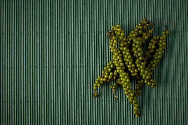 Pimienta con papel verde corrugado. Concepto de hierbas tropicales. Espacio vacío para el diseño
 - Foto, imagen