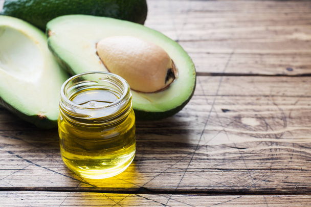 Avocado and avocado oil on wood background with copy space - Photo, Image