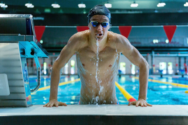 Professional swimmer emerges from the pool. Selective focus. - Foto, afbeelding