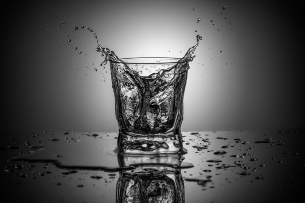 Photographie noir et blanc d'éclaboussures d'eau dans un élégant verre à whisky sur fond dégradé
 - Photo, image